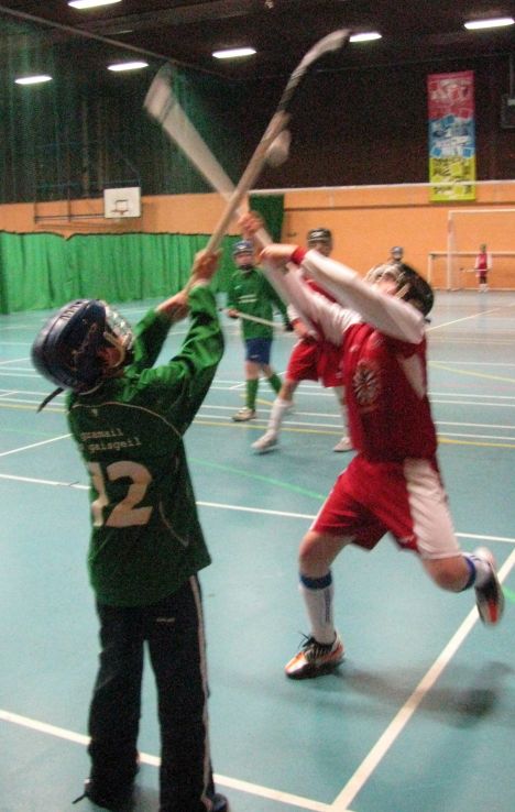 indoor shinty match Edinburgh player competes for a throw-up ball in an indoor shinty tournament